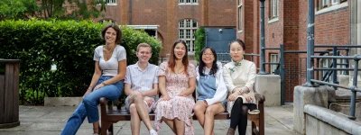 Group photo of 2023/24 Officer Trustees, sitting on a bench in Beit Quad