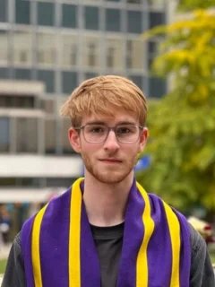 A headshot of Ed in front of the Queens Lawn and Sherfield Building.